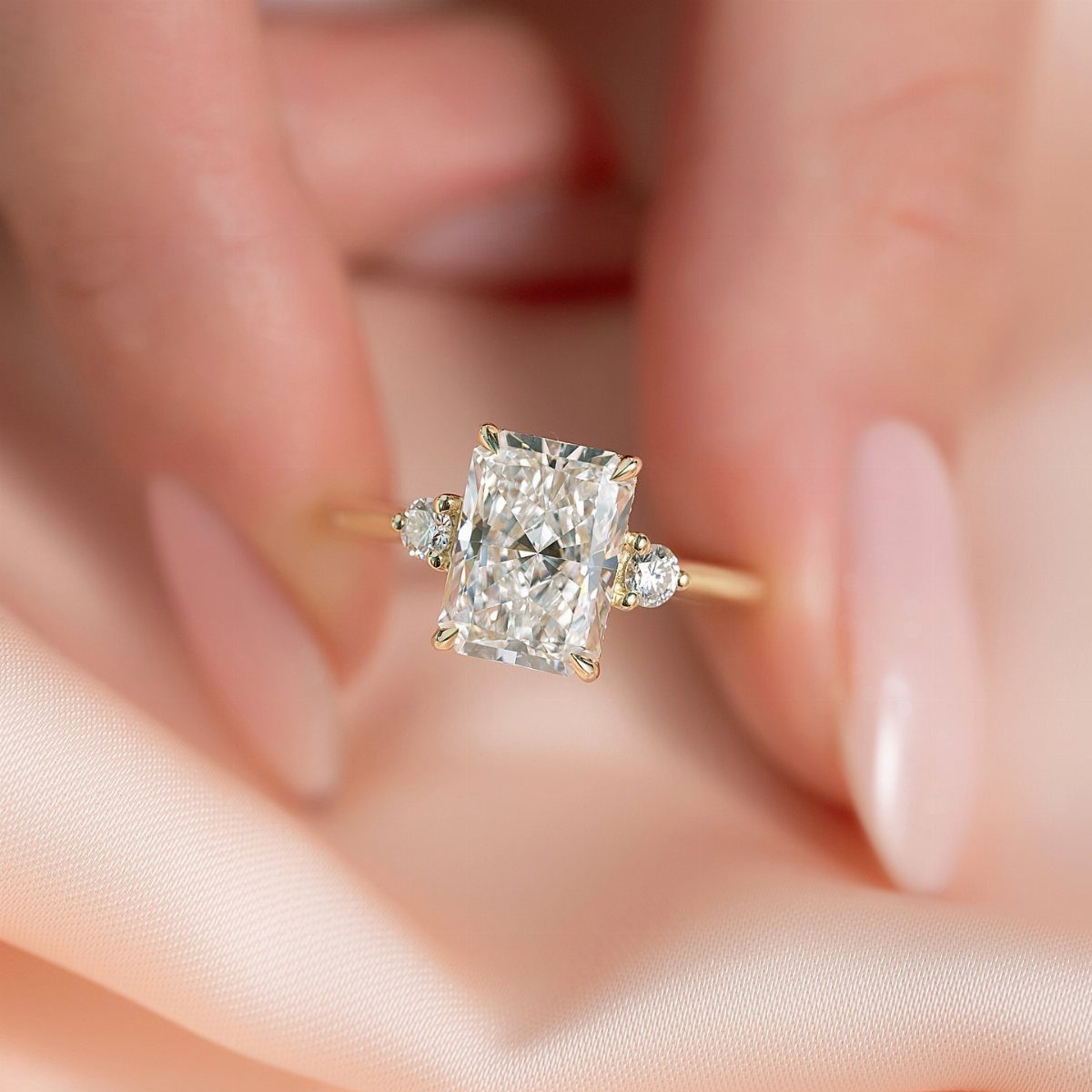 Yellow gold ring with a rectangular center diamond and two side stones.