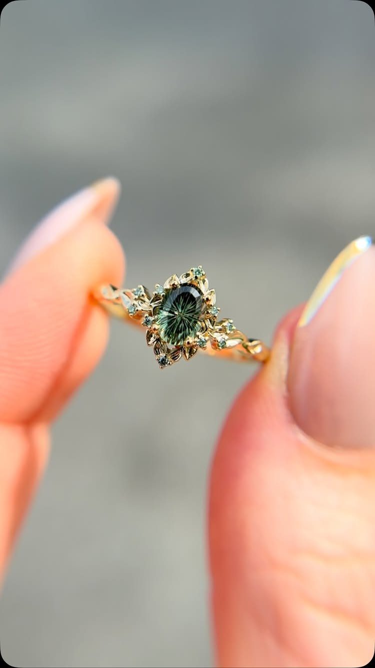 Gold ring with dark green oval gemstone and ornate antique diamond setting