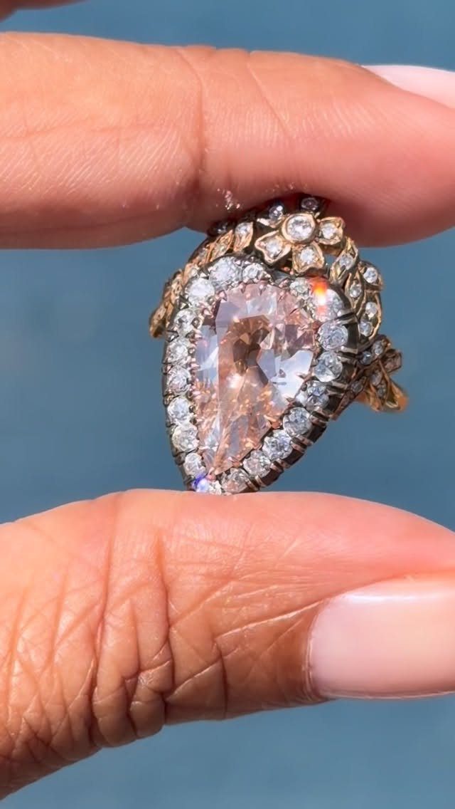 Antique gold ring with pear-shaped champagne diamond and floral diamond cluster detail.