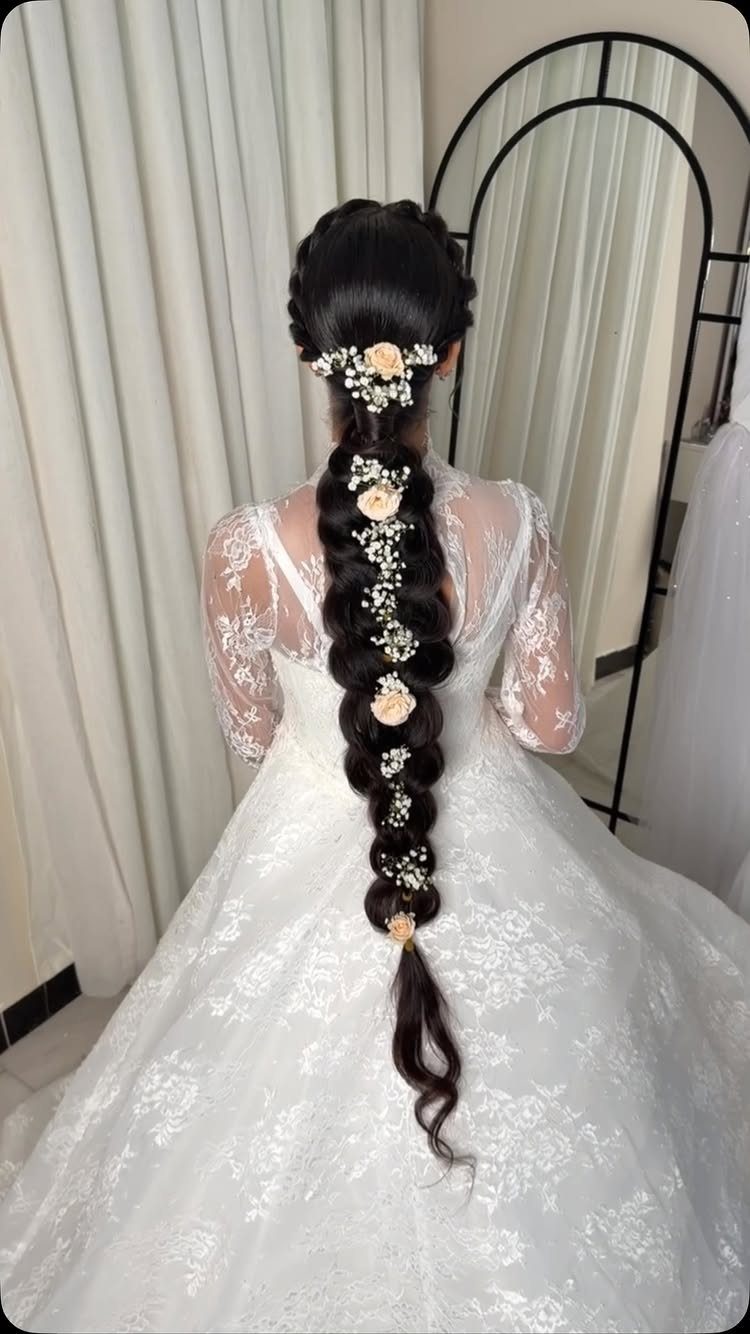 Bride in white lace wedding dress with floral accessories in her braided hair