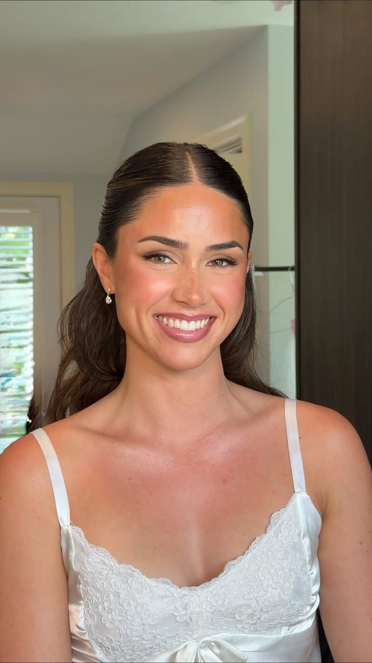 Woman with green eyes wearing bridal makeup and a white lace satin slip.
