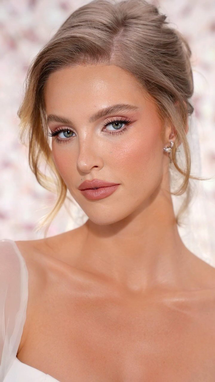 Woman with pale skin wearing bridal makeup and a white wedding dress