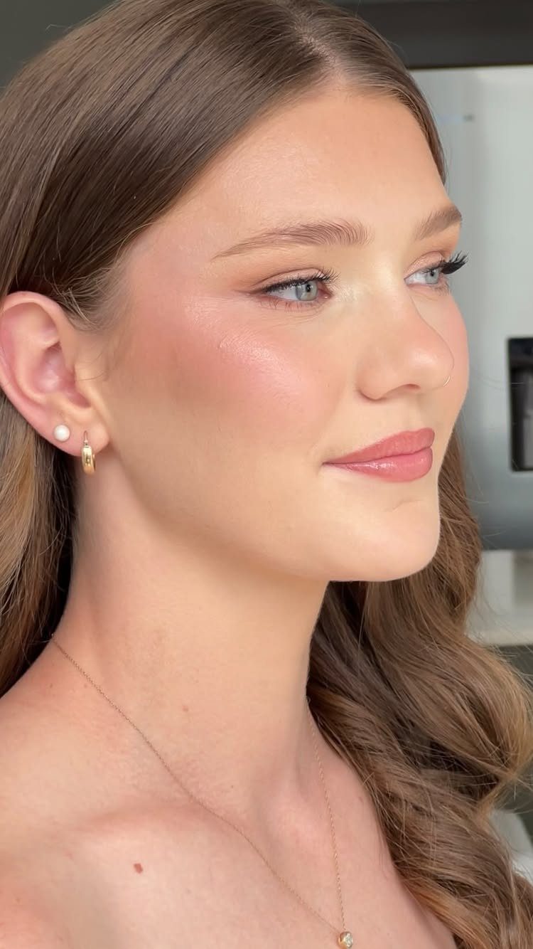 Woman with pale skin wearing sheer pink blush and soft bridal makeup.