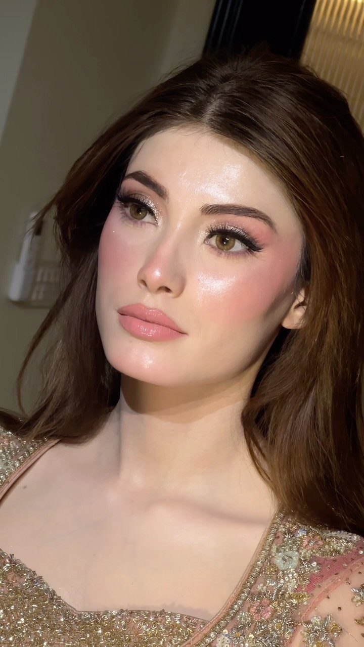 Woman with bridal makeup showing glowing highlighter on her cheekbones and nose.