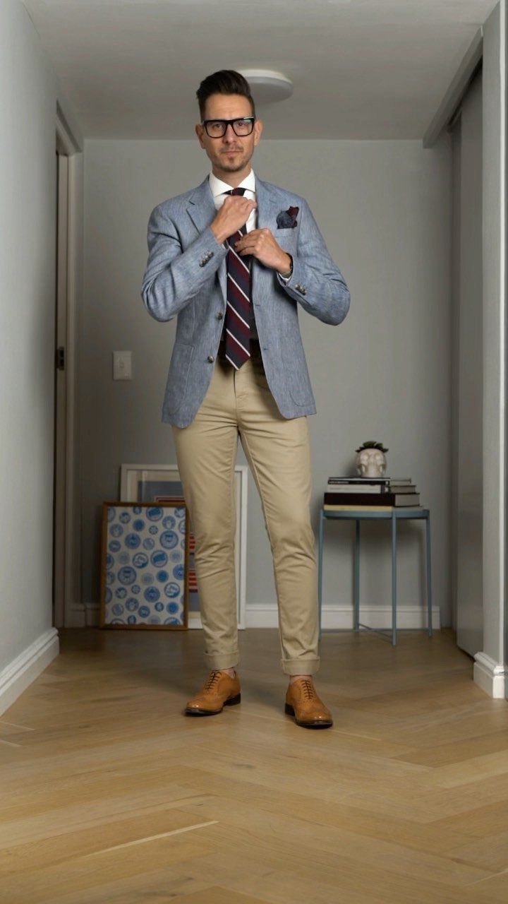 Man wearing tan tailored chinos, light blue blazer, and brown leather dress shoes.