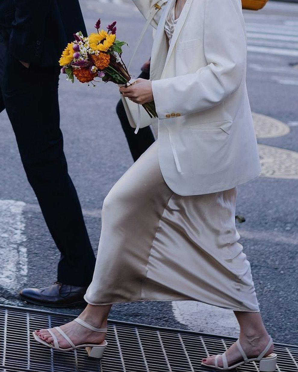 Champagne satin slip dress paired with a white blazer and colorful bridal bouquet.