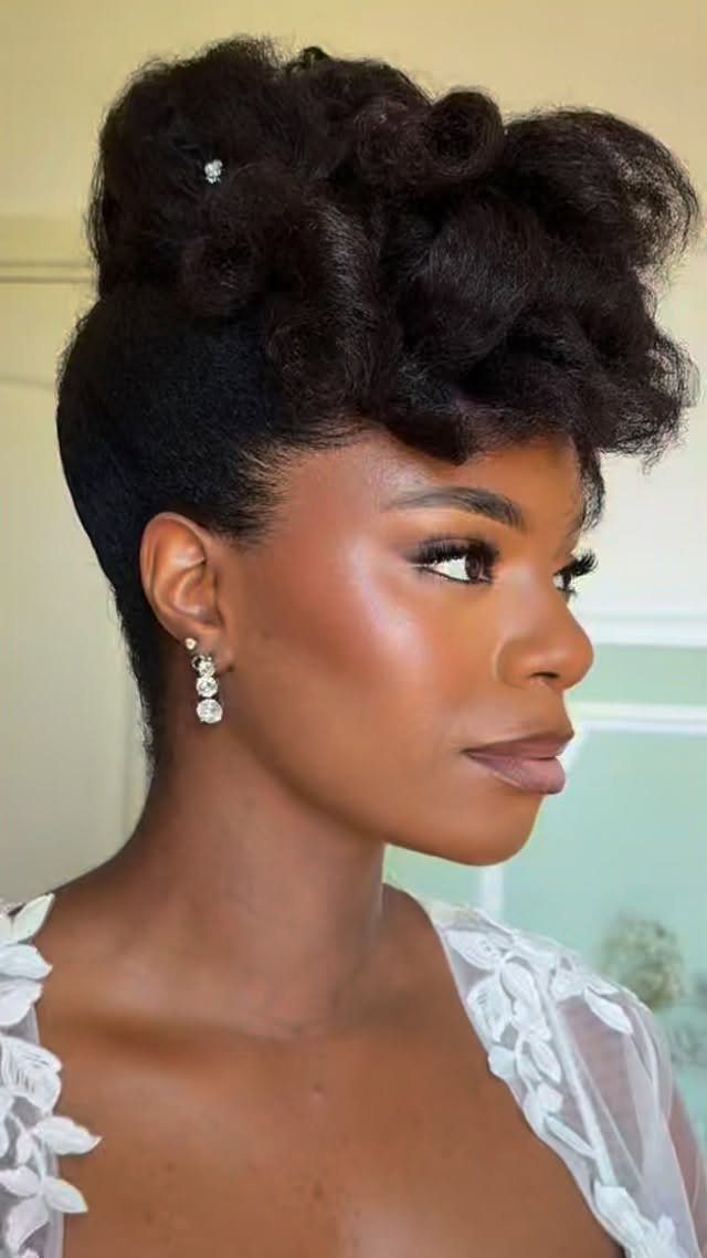 Bride with dark skin wearing glowy natural makeup and an elegant updo hairstyle.