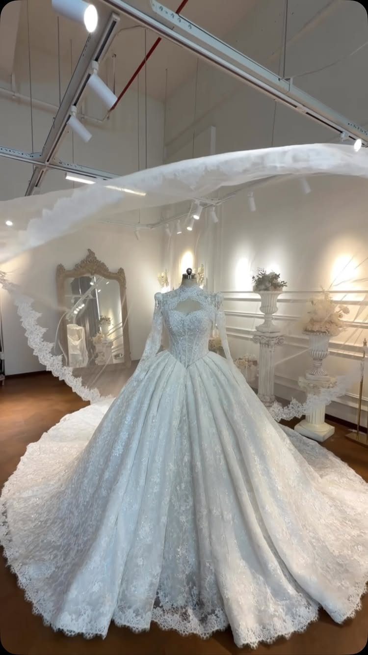 White lace ball gown wedding dress with a voluminous skirt on a mannequin.