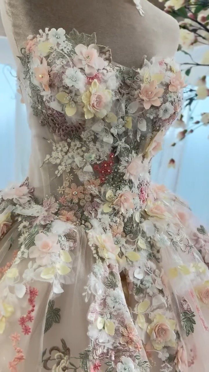 Floral ball gown with 3D cream and pink flower appliqués on a mannequin