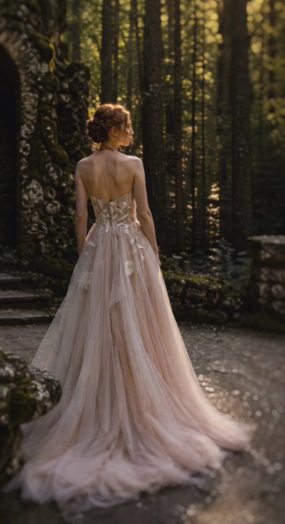 Woman in a light pink A-line wedding gown standing in a sunlit forest