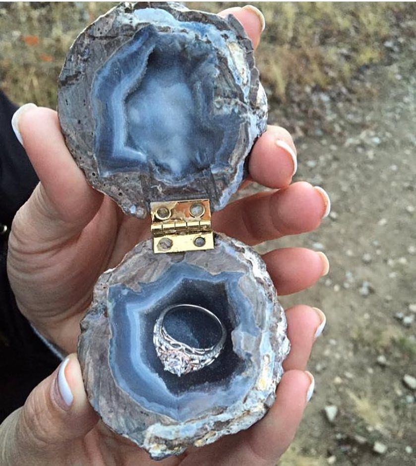 Geode ring box made from blue crystals holding a silver diamond engagement ring.