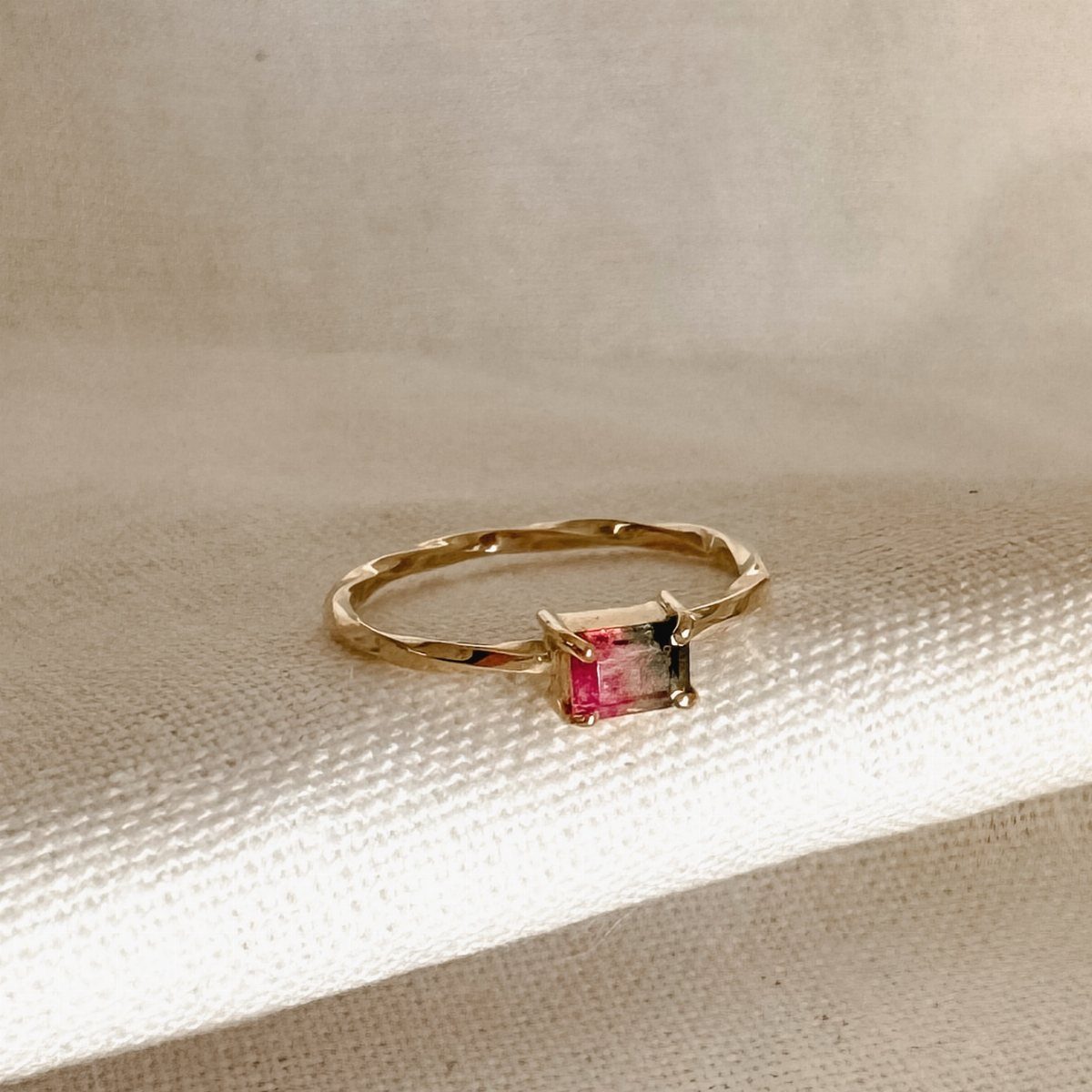 Gold ring with a rectangular bicolor pink and green watermelon tourmaline gemstone.