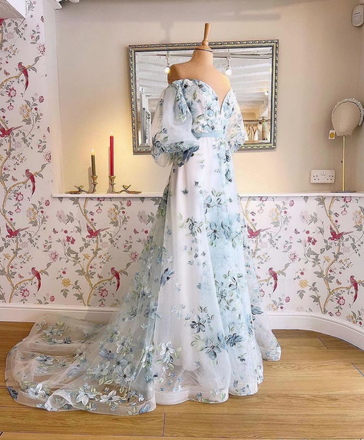 White ball gown wedding dress with blue floral patterns on a mannequin