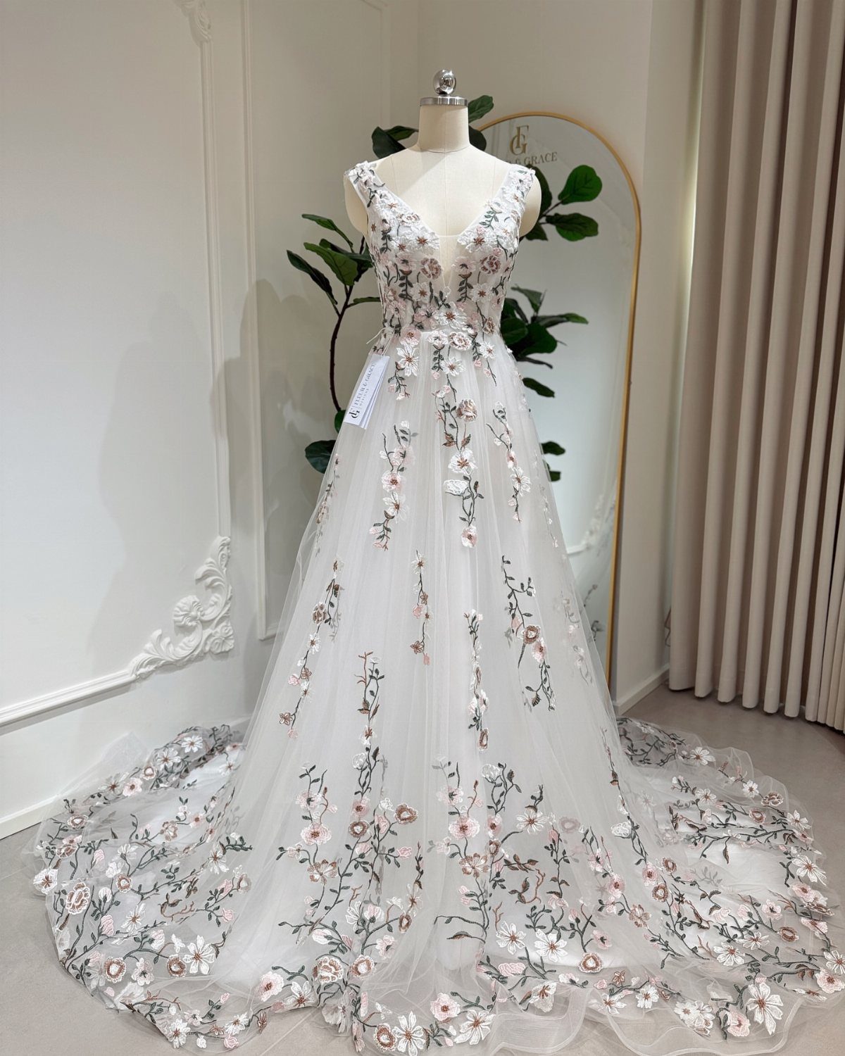 White ball gown wedding dress with multicolored floral embroidery on a mannequin