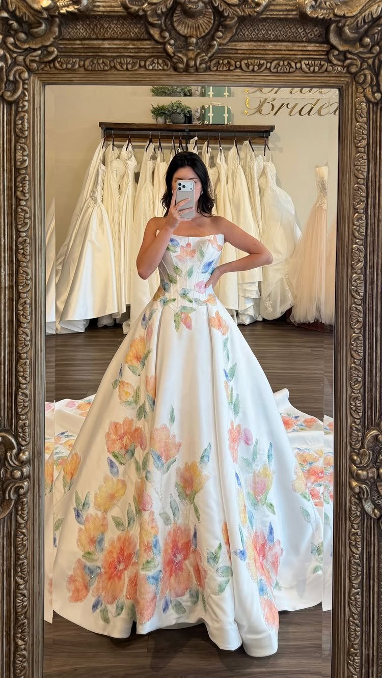 Woman in a strapless white ball gown wedding dress with colorful floral prints.