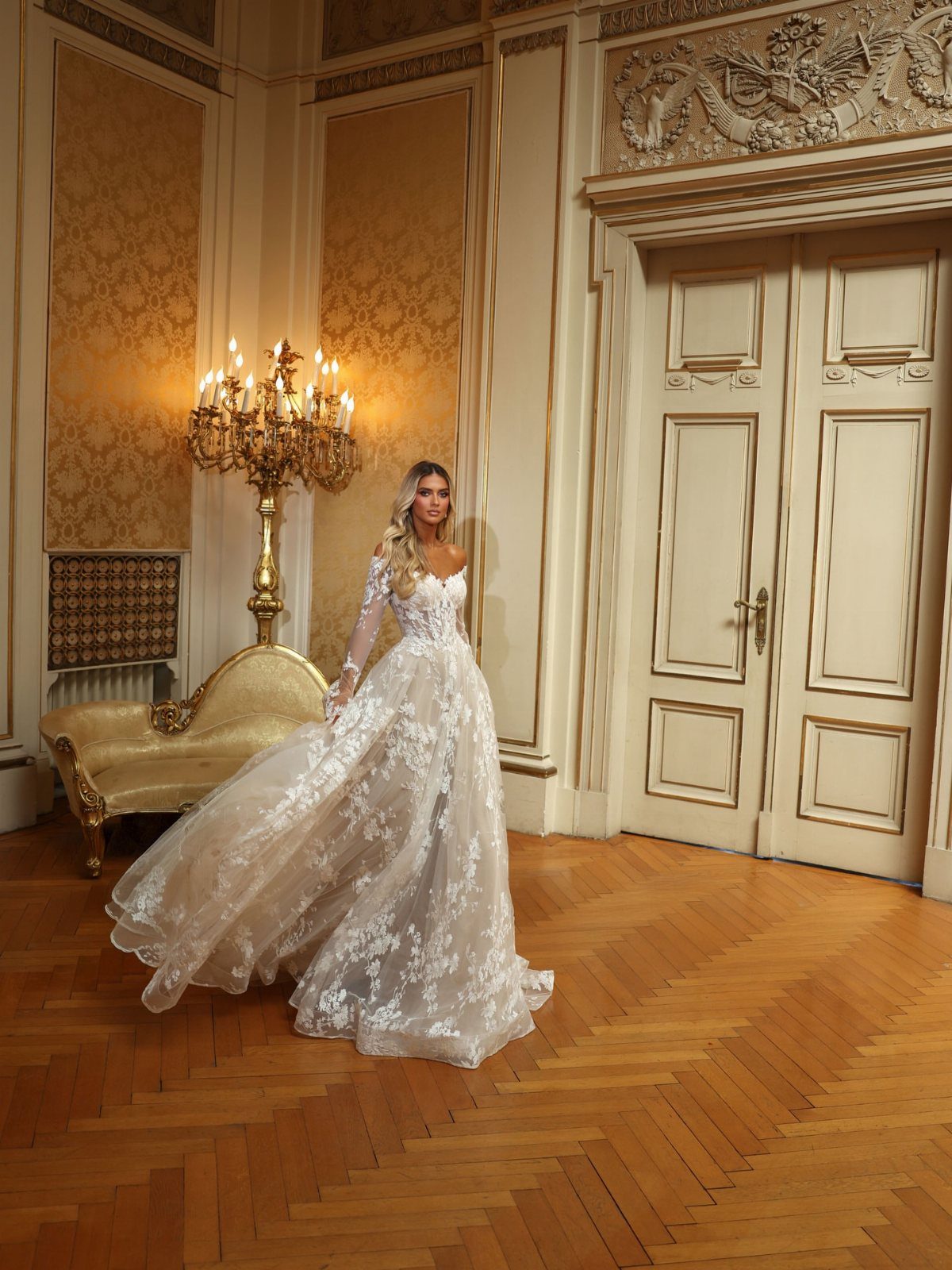 Woman in a white floral lace ball gown wedding dress in an ornate room