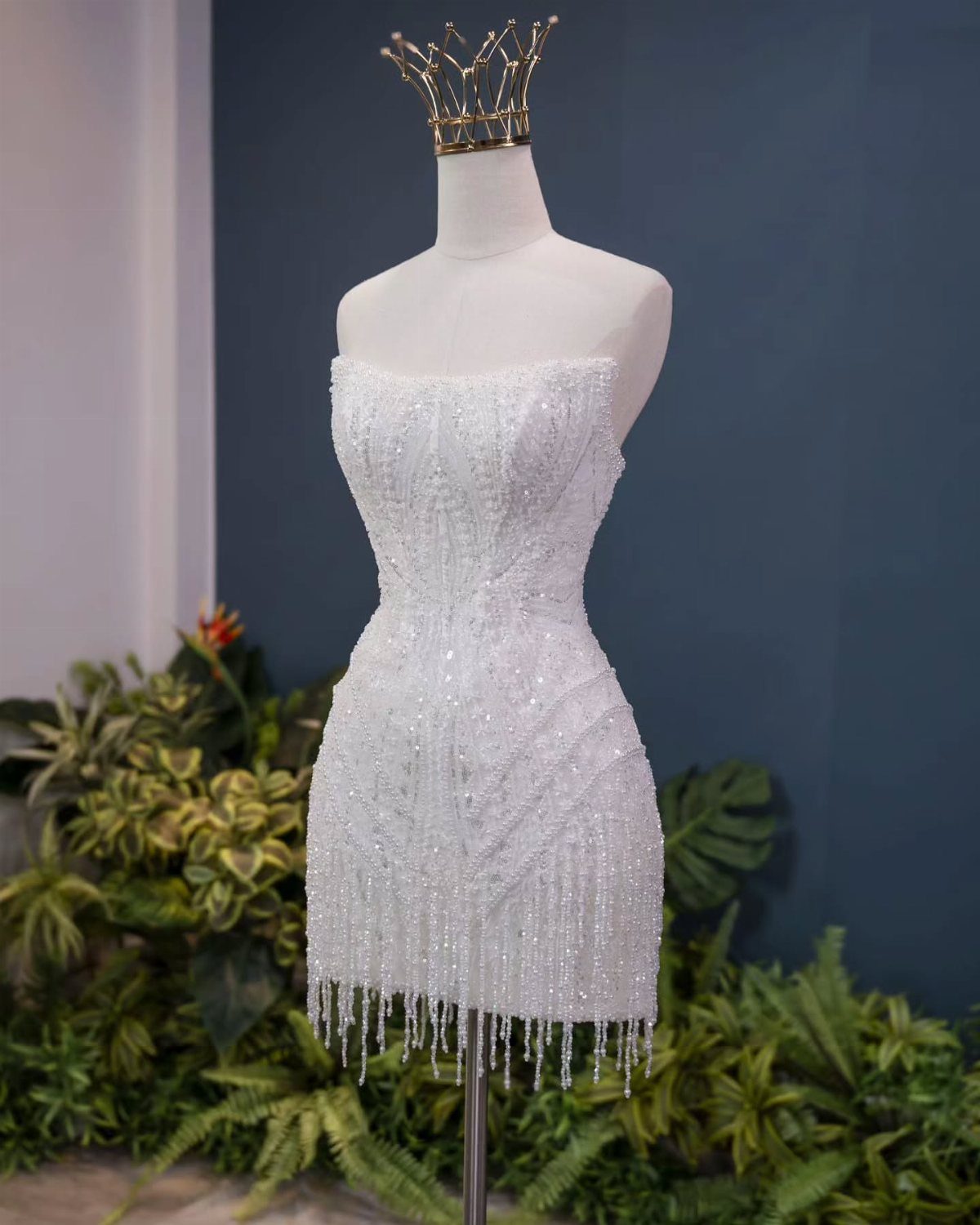 White strapless mini dress with heavy beadwork and fringe on a mannequin