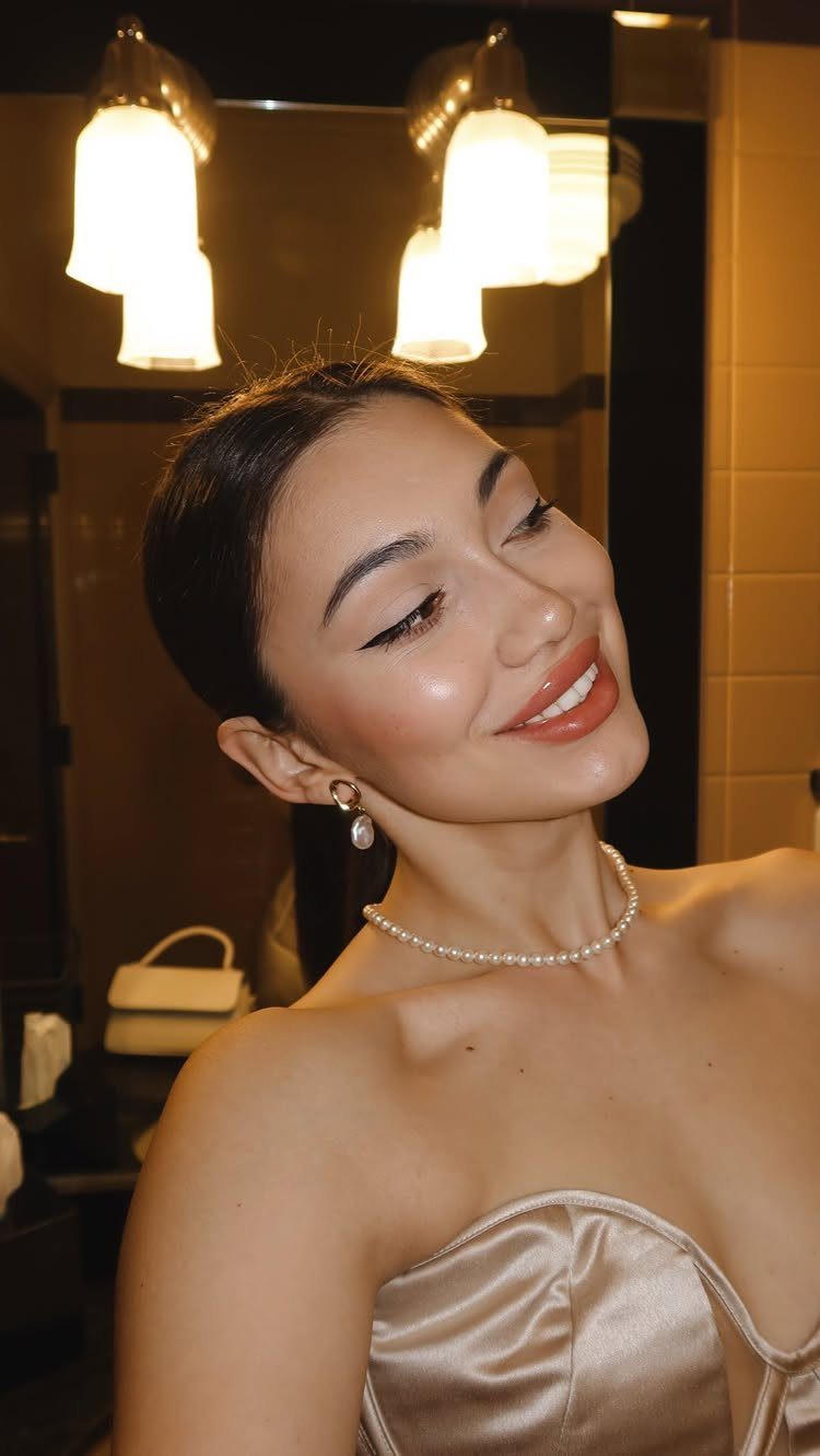 Woman in strapless champagne dress wearing a pearl necklace and pearl earrings.