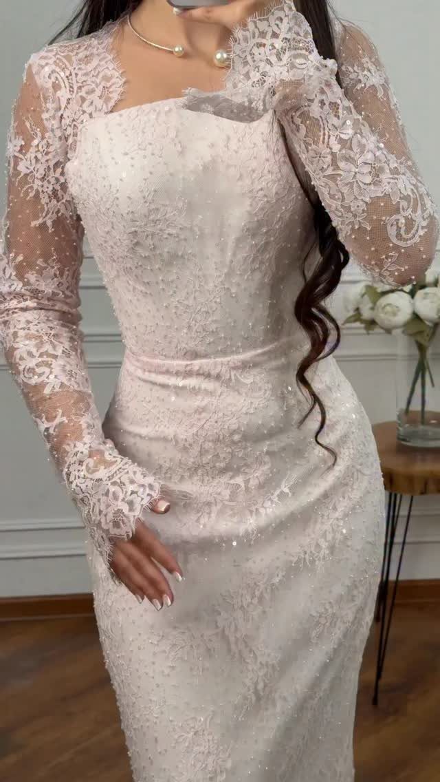 Long sleeve lace wedding dress with sparkling sequins on a woman.