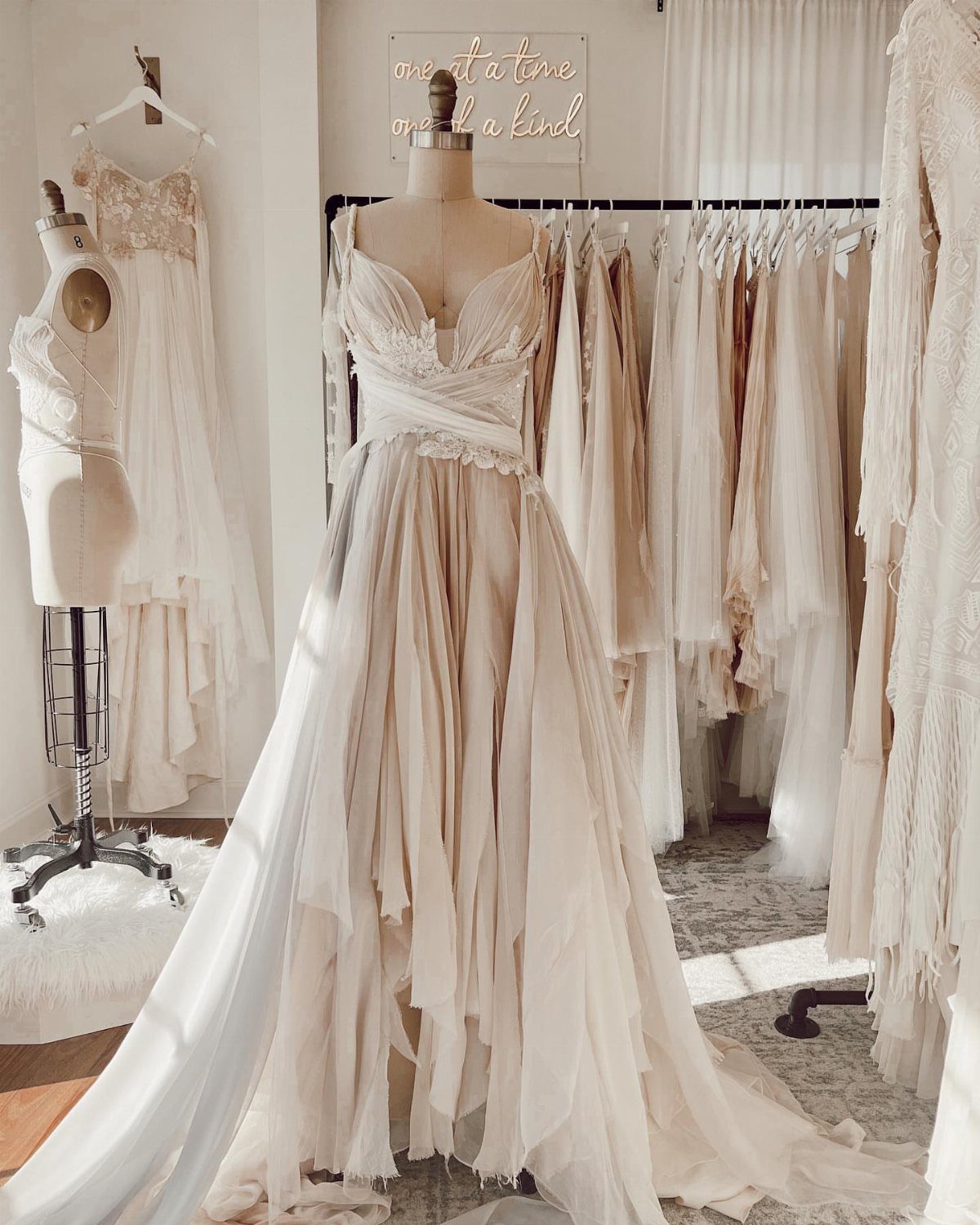 White wedding dress with lace bodice and flowing chiffon skirt on a mannequin