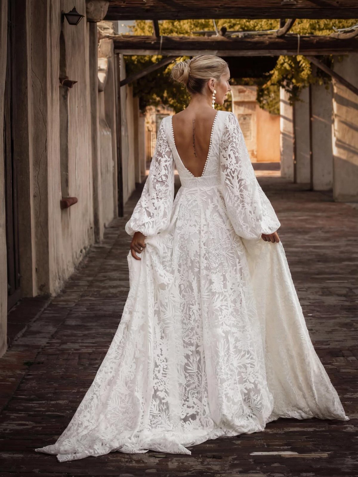 Woman in a long white lace boho wedding dress with balloon sleeves