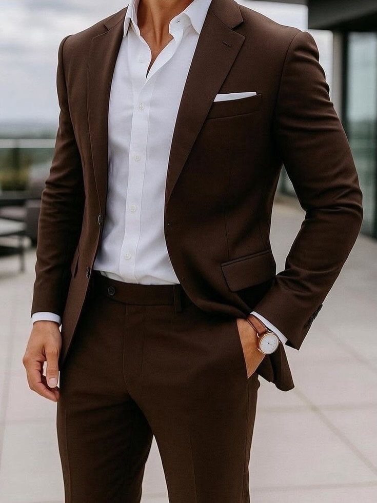 Man wearing a tailored dark brown suit and white shirt on a terrace