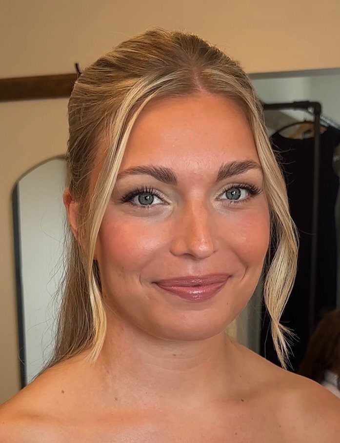 Blonde woman with natural bridal makeup, neutral eyeshadow, and glossy pink lips.