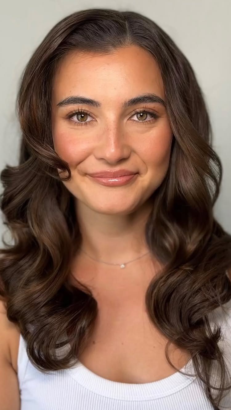 Woman with radiant skin and soft makeup posing for a close-up portrait.