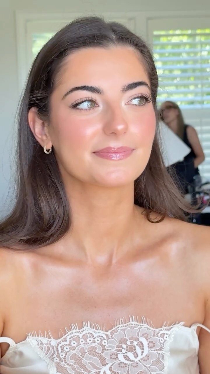 Woman in white lace bridal dress with natural, glowing skin and soft makeup.