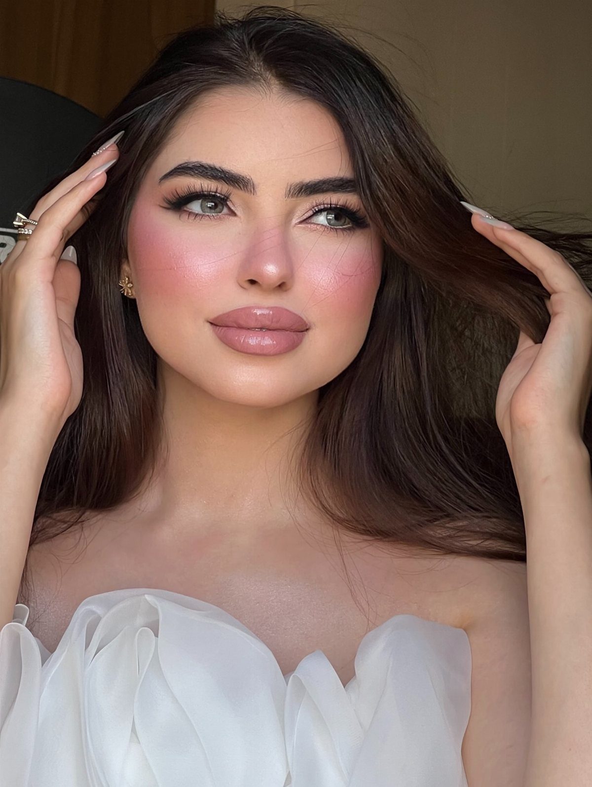 Woman in white dress with soft pink blush and nude bridal makeup look