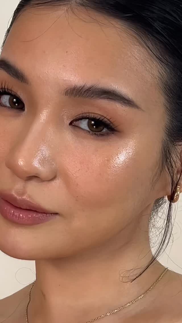 Woman with glowing dewy makeup, glossy lips, and neutral tones for a romantic look.