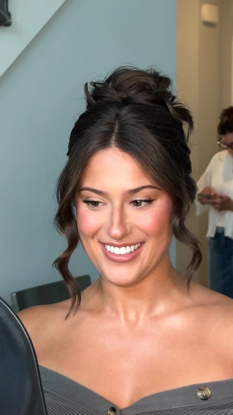 Woman with fair skin wearing natural makeup and soft pink blush smiling.