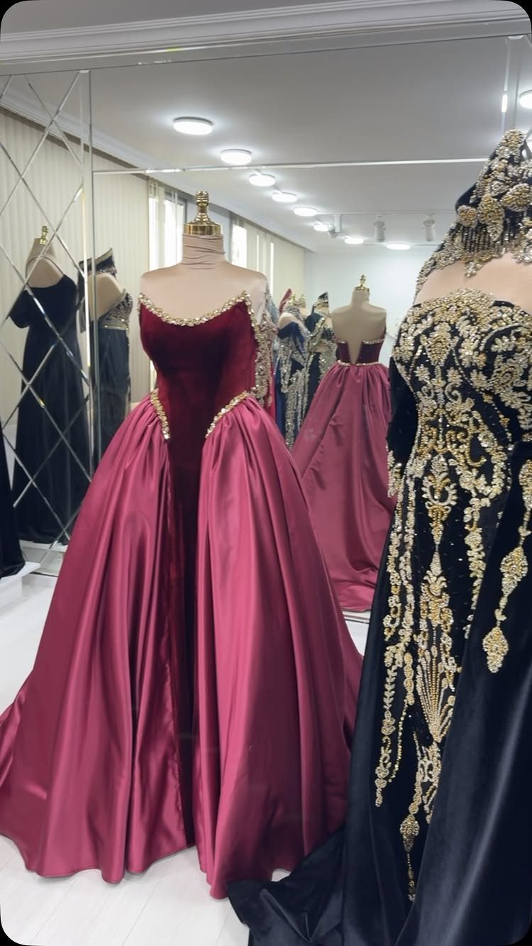 Maroon velvet and satin ballgown with gold embroidery on a boutique mannequin