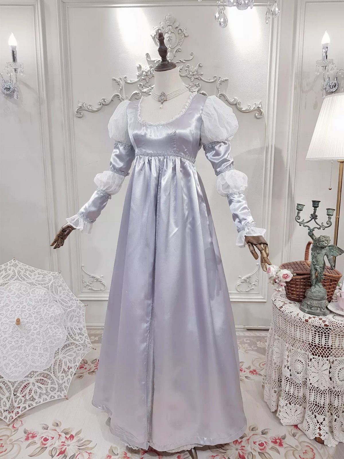 Silver-white satin vintage style wedding dress on a mannequin in an ornate room