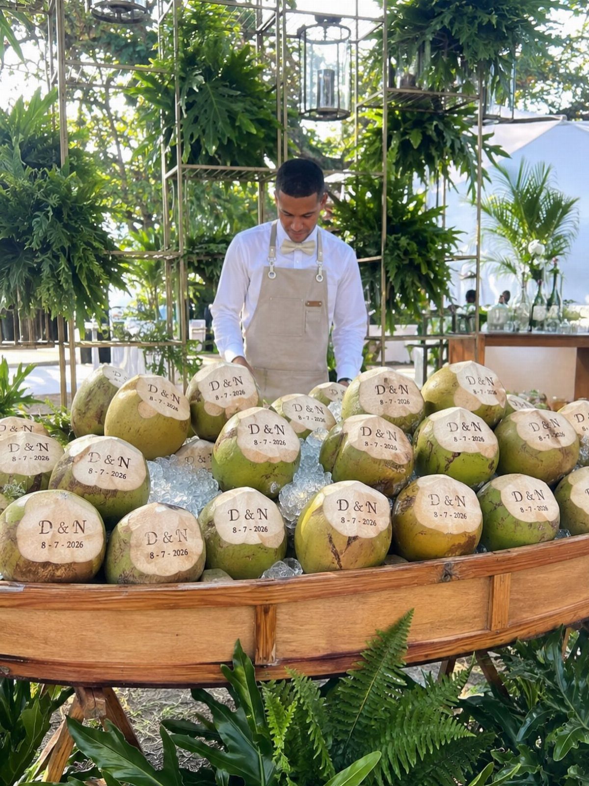 Carved coconuts with initials and date displayed on ice in a wooden boat.