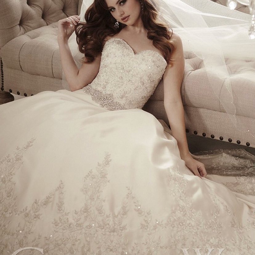 Woman in a white strapless wedding dress with a sweetheart neckline and beaded bodice.
