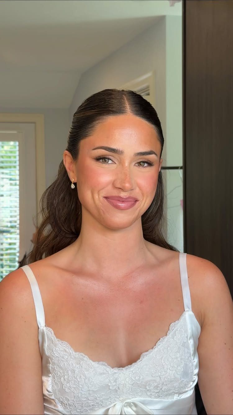 Woman with soft glam makeup and neutral tones wearing a white lace camisole.