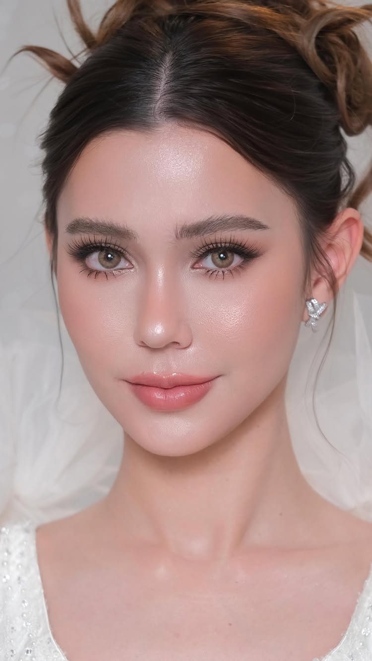 Asian bride with soft neutral makeup, glowing dewy skin, and an elegant updo.
