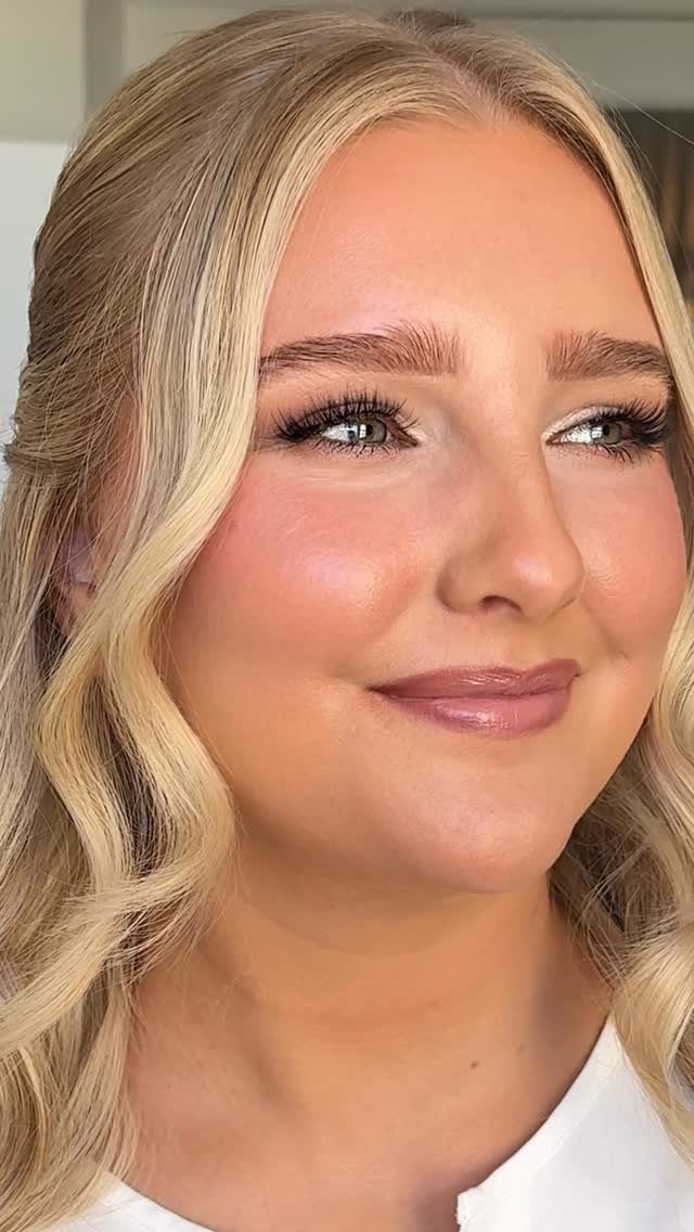 Blonde woman with glowing dewy skin and soft natural bridal makeup.