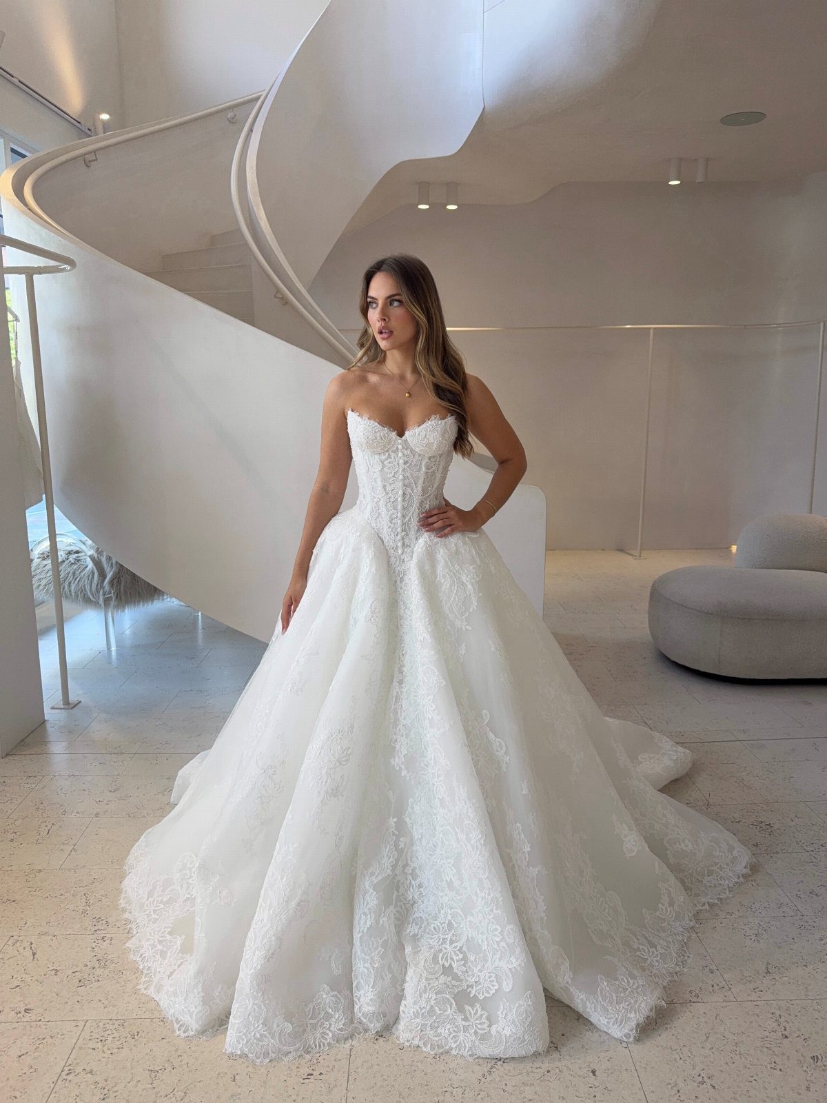 Woman in a white strapless wedding dress with a corset bodice and lace skirt.