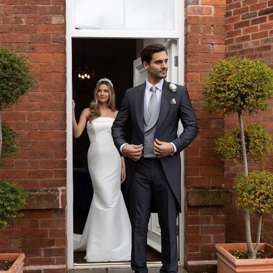 Man in charcoal grey morning suit and woman in white wedding dress.