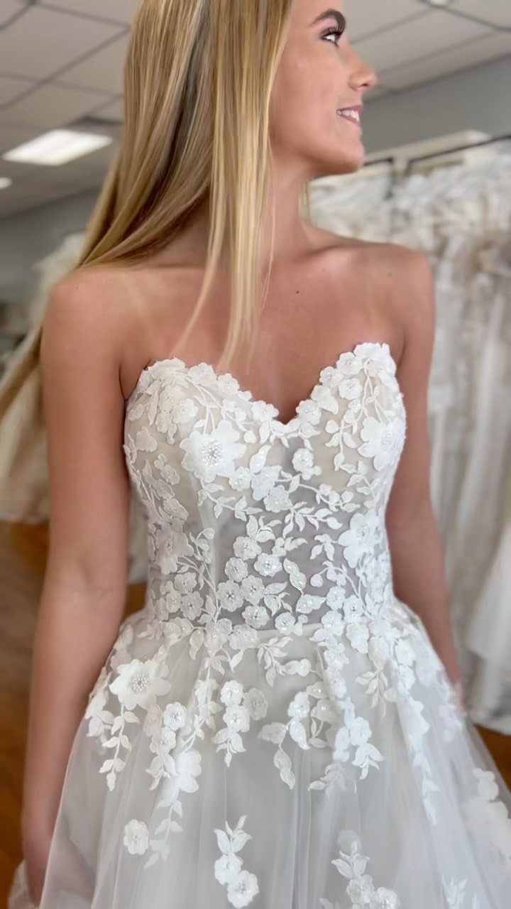 Woman wearing a white lace wedding dress with a romantic sweetheart neckline