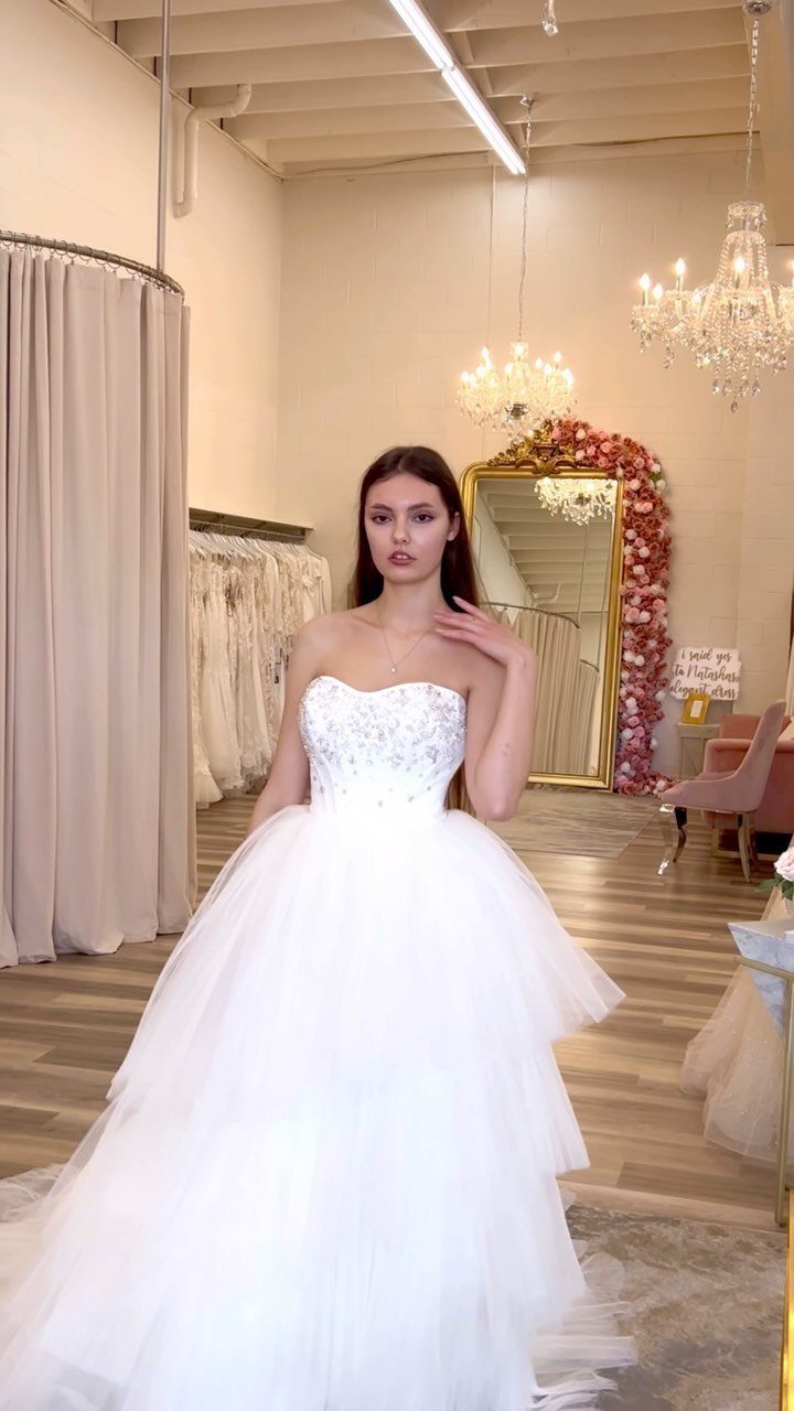Woman in a white sweetheart neckline wedding dress with a tiered tulle skirt.