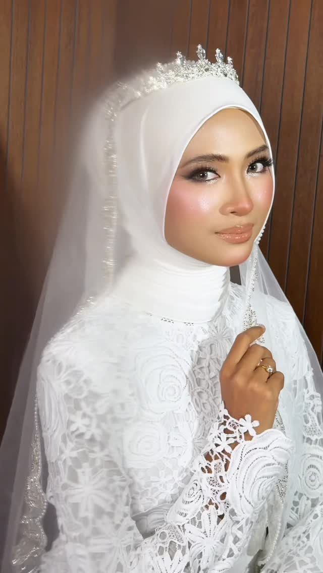 Bride with tan skin wearing white hijab and lace dress with wedding makeup