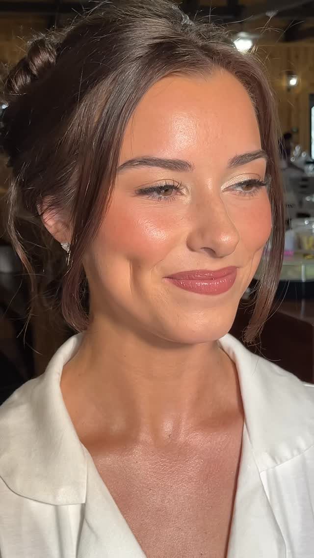 Woman with glowing skin, shimmery gold eyeshadow, and glossy pink lips.