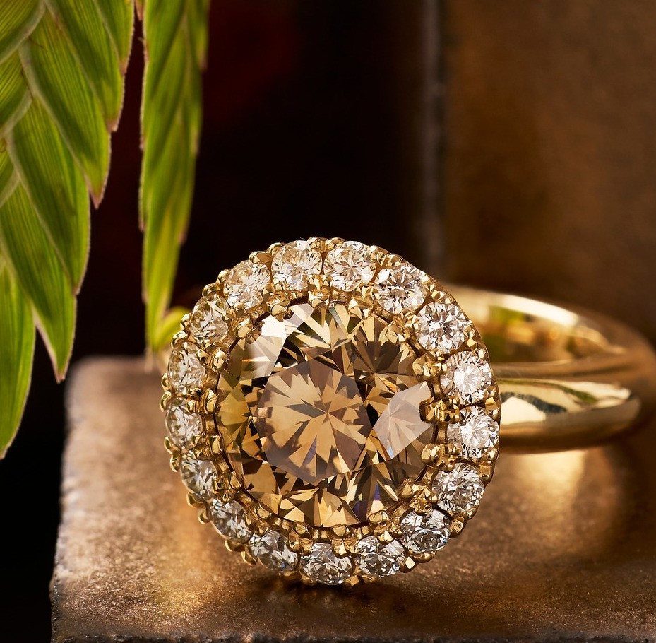 Champagne colored diamond engagement ring with a halo of clear diamonds on gold band