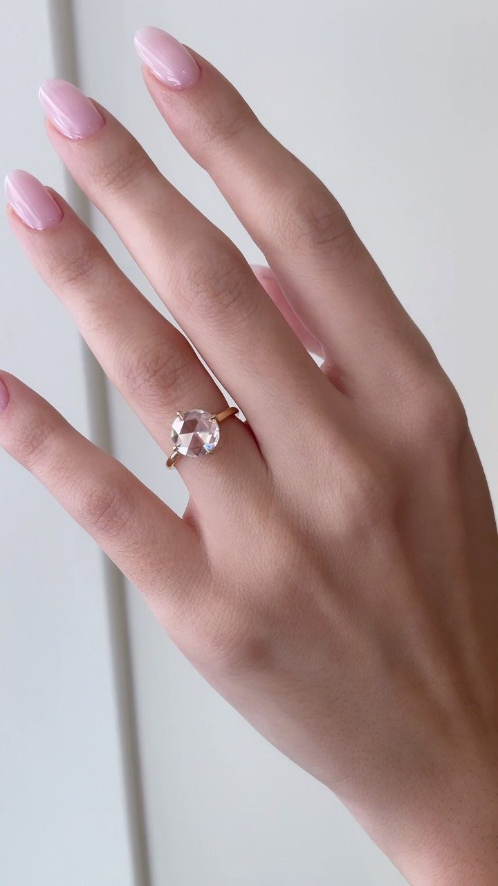 Rose cut diamond ring on a finger with light pink manicured nails.