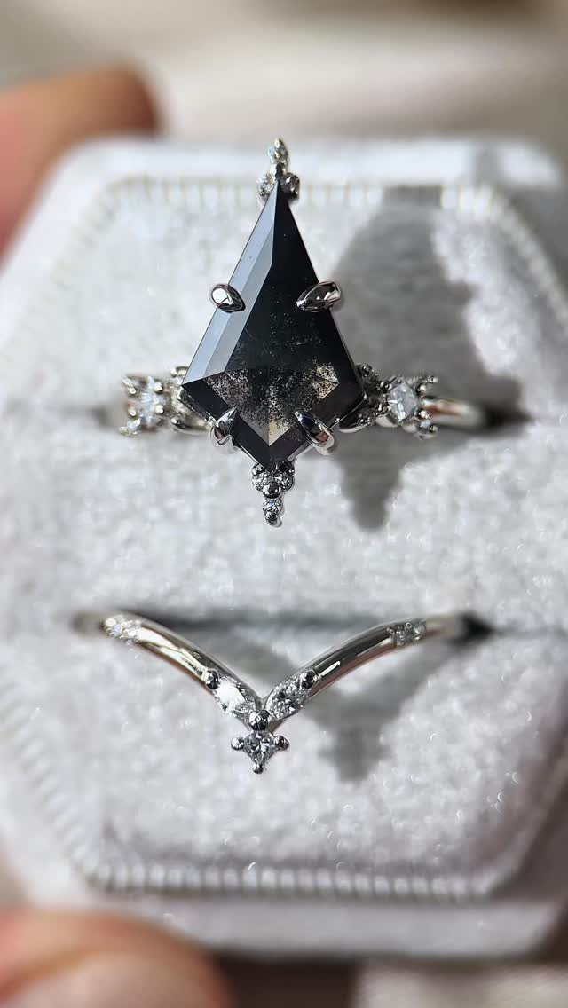 Kite-shaped salt and pepper diamond ring with a matching V-shaped wedding band.