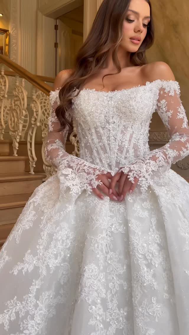 Woman in a white lace wedding dress with a structured corset bodice and sleeves.