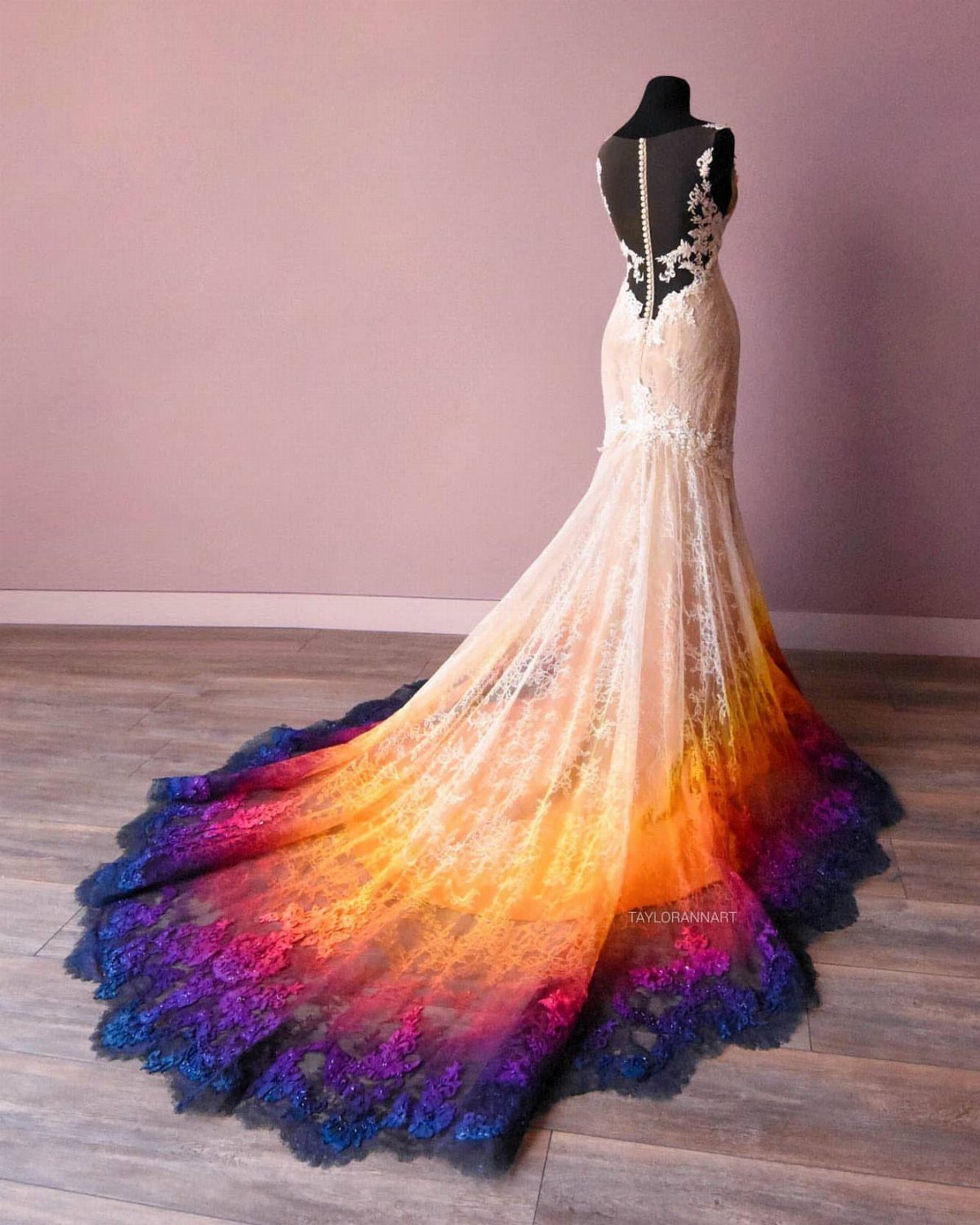 Mermaid wedding dress with a colorful gradient train in orange, purple, and blue.
